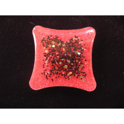 Square ring, black microbeads, on a red resin background