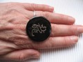 Large graphic ring, Asian print, on black resin background