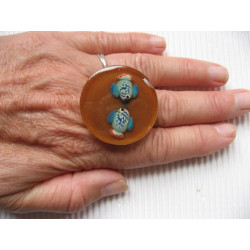 Large summer ring, fishes in love, on a background of sand in resin