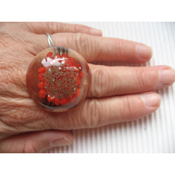 Very large cabochon ring, silver microbeads, on a red resin background