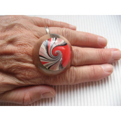 Very large cabochon ring, white and red spiral, on transparent resin background