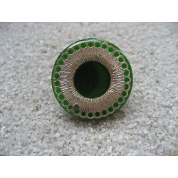 RING graphic, silver print, on green resin background