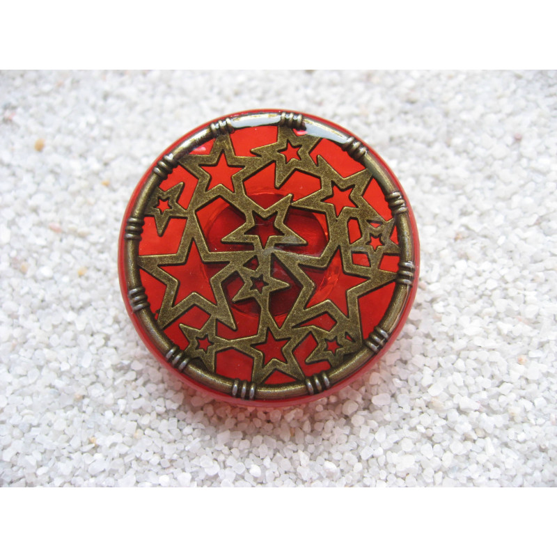 Large graphic ring, bronze stars, on a red resin background