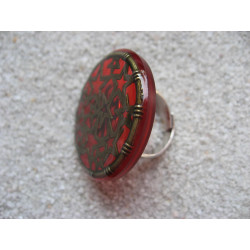 Large graphic ring, bronze stars, on a red resin background