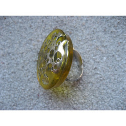 Large graphic ring, perforated silver stamp, on a yellow resin background