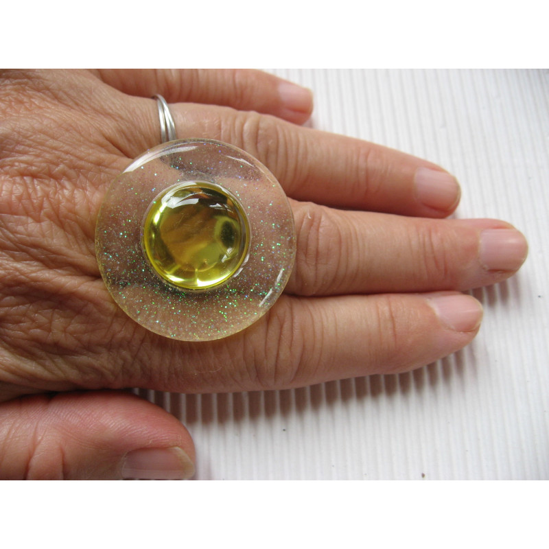 Big graphic ring, yellow pearl, on a white resin background