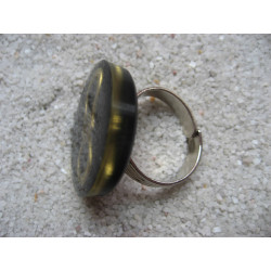 Fancy ring, bronze infinity charm, on black resin background