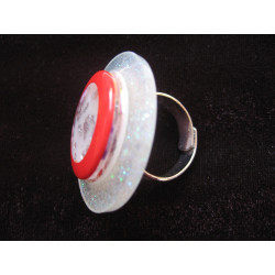 Large graphic ring, transparent red cabochon with flowers, on a pearly white resin background