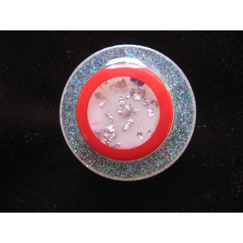 Large graphic ring, transparent red cabochon with flowers, on a pearly white resin background