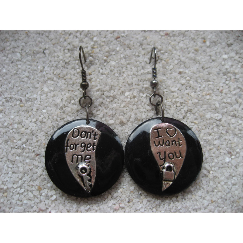 Asymmetrical earrings, silver hearts, on a black resin background