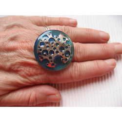 Large adjustable ring, silver print with holes, on turquoise resin background