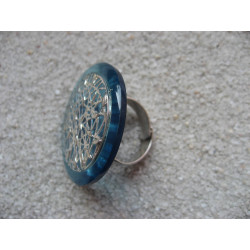 Large ring, silver print, on blue resin background
