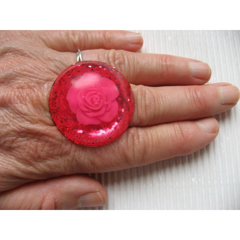 Large cabochon ring, pink flower, on fuchsia resin background