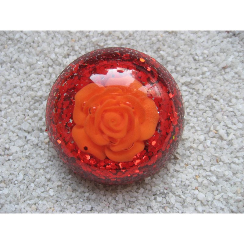 Large cabochon ring, orange flower, on an orange glittery resin background