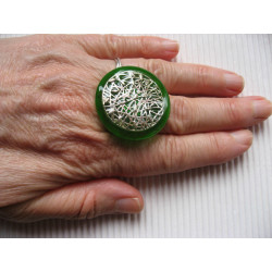 Large graphic ring, silver print, on a green resin background