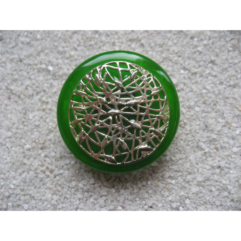 Large graphic ring, silver print, on a green resin background