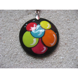 Cabochon pendant with multicolored patterns on a black background in fimo