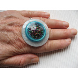 Very large ring, multicolored glitter cabochon, on an turquoise and white pearlescent resin background