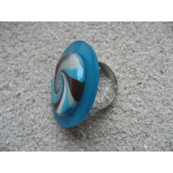 Grande bague, spirale turquoise et marron en fimo, sur fond bleu en résine