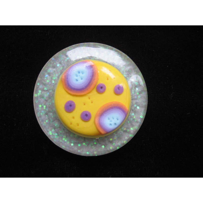 Large ring, multicolored cabochon on a yellow fimo background, on a pearly white resin background