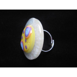 Large ring, multicolored cabochon on a yellow fimo background, on a pearly white resin background