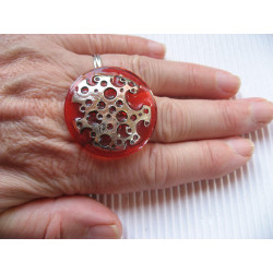 Large graphic ring, perforated silver print, on orange resin background