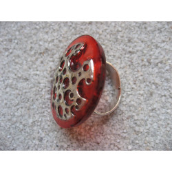 Large graphic ring, perforated silver print, on orange resin background