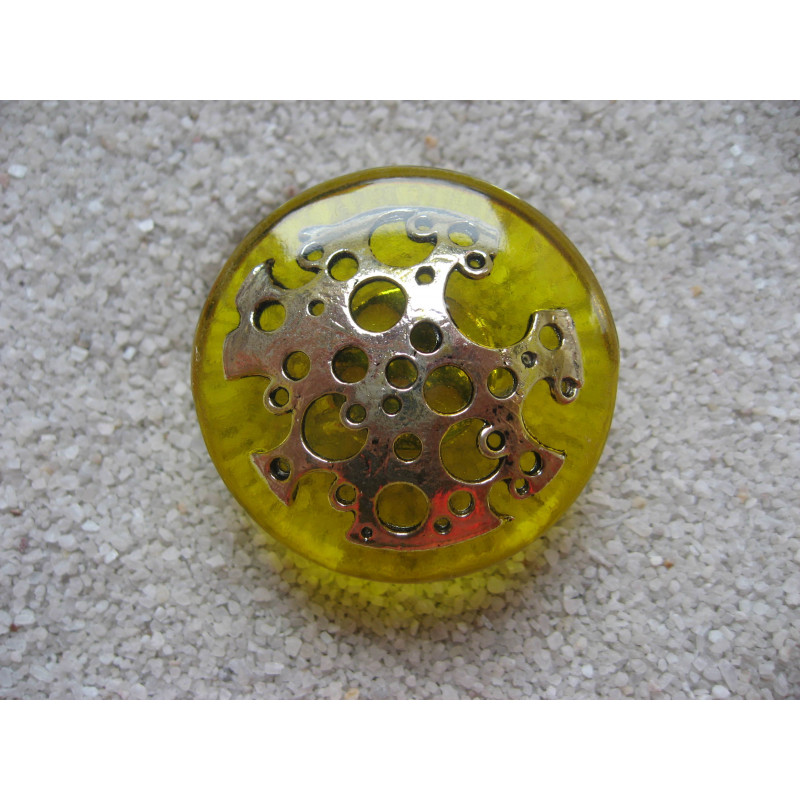 Large graphic ring, perforated silver stamp, on a yellow resin background